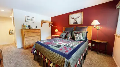 a bedroom with a bed and a red wall at La Residence - Shared Pool Hot Tub & More in Mammoth Lakes