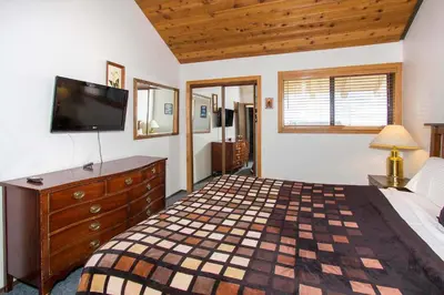 a bedroom with a bed and a dresser with a television at La Vista Blanc #22 - Near Shuttle BBQ & Pool in Mammoth Lakes