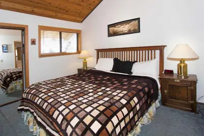 a bedroom with a bed and a table with a lamp at La Vista Blanc #22 - Near Shuttle BBQ & Pool in Mammoth Lakes