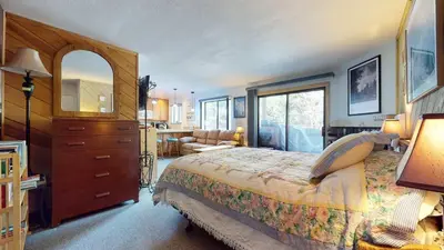 a bedroom with a large bed with a dresser and a chair at La Vista Blanc with Year-Round Mammoth Fun in Mammoth Lakes
