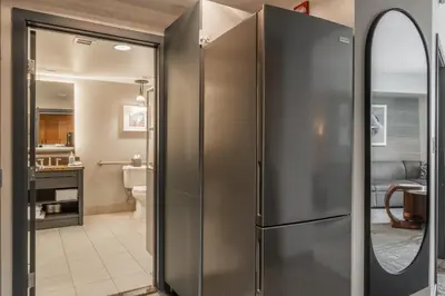 a stainless steel refrigerator in a kitchen with a mirror at 2 BDR Family Resort Condo with Pool Lounge & Mountain Views in Mammoth Lakes