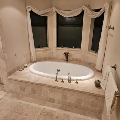 a large tub in a bathroom with two windows at Waterfront Elegance in Discovery Bay