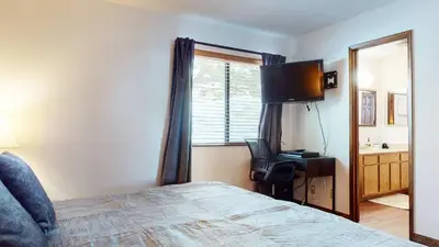 a bedroom with a bed and a desk and a window at Mammoth Hygge - Centrally Located in Mammoth Lakes