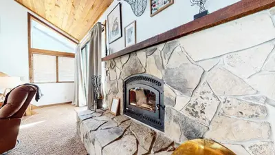 a stone fireplace in a living room with a stone wall at Mammoth Hygge - Centrally Located in Mammoth Lakes