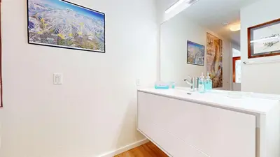a white bathroom with a sink and a mirror at Cozy Cabin for 6 - Near Canyon Lodge & Slopes in Mammoth Lakes