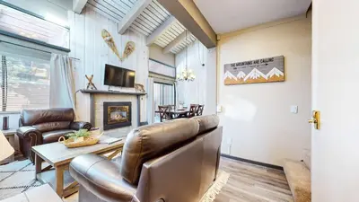 a living room with a leather couch and a table at Modern Cabin for Family of 8 - Near Slopes & Canyon Lodge in Mammoth Lakes