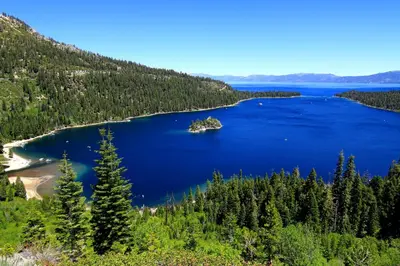a view of a lake in the middle of a forest at The Cozy Cub Cabin 7 Min to Lake in South Lake Tahoe