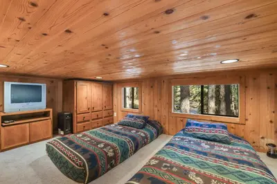 a bedroom with two beds and a television in a cabin at The Cozy Cub Cabin 7 Min to Lake in South Lake Tahoe