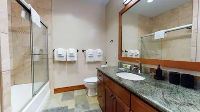 a bathroom with a sink and a shower and a toilet at Red Slate Canyon - Modern 2-Story Condo in Mammoth Lakes
