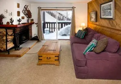 a living room with a purple couch and a wooden table at Mammoth View Villas - Shop Hike or Golf in Mammoth Lakes