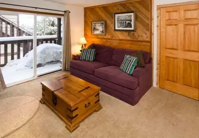 a living room with a purple couch and a coffee table at Mammoth View Villas - Shop Hike or Golf in Mammoth Lakes