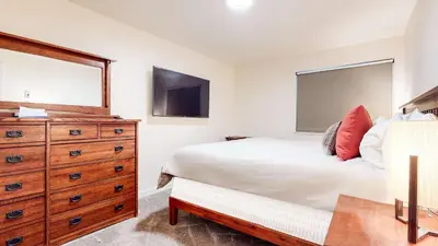 a bedroom with a bed and a dresser and a mirror at Mid Century Modern Cabin #212 - Walk to Village in Mammoth Lakes
