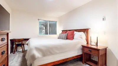 a bedroom with a large bed and a window at Mid Century Modern Cabin #212 - Walk to Village in Mammoth Lakes
