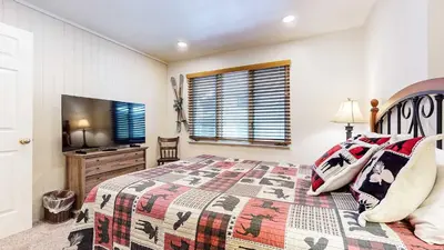 a bedroom with a bed and a flat screen tv at Mountain Chateau Retreat - Desirable Resort 4 BDR in Mammoth Lakes