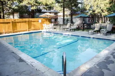 a swimming pool with blue water in a yard at Mountain Shadows #B08 - Near Hike Bike & Ski in Mammoth Lakes