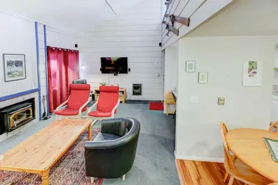a living room with red chairs and a table at Mountain Shadows #B08 - Near Hike Bike & Ski in Mammoth Lakes