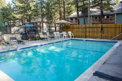 a large blue swimming pool with chairs and umbrellas at Mountain Shadows #F02 - Near Shuttle & Shopping in Mammoth Lakes