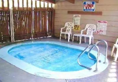 a swimming pool with two chairs and a table at Mountain Shadows #F02 - Near Shuttle & Shopping in Mammoth Lakes