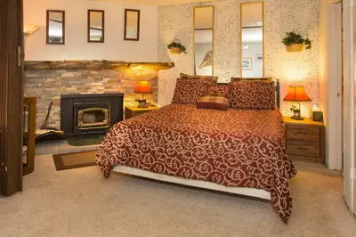 a bedroom with a large bed and a fireplace at Mountain Shadows #F02 - Near Shuttle & Shopping in Mammoth Lakes