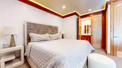 a bedroom with a large white bed and a chair at Obsidian Ski & Golf Villa - 3 BDR Prime Location in Mammoth Lakes