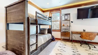 a bedroom with bunk beds and a flat screen tv at Obsidian Ski & Golf Villa - 3 BDR Prime Location in Mammoth Lakes