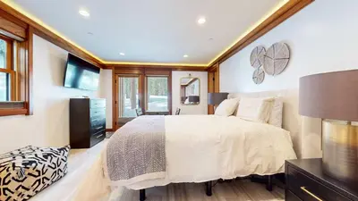 a bedroom with a large bed and a television at Obsidian Ski & Golf Villa - 3 BDR Prime Location in Mammoth Lakes