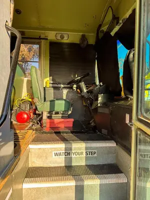 an open door of a vehicle with a chair in it at The Magic Skoolie in Visalia