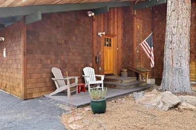 a cabin with two chairs and an american flag at Sundance - Foosball Table BBQ Near West Beach in Carnelian Bay