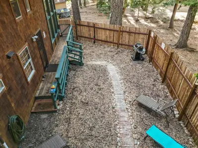 a backyard with a fence next to a house at Sundance - Foosball Table BBQ Near West Beach in Carnelian Bay