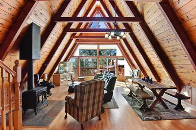 a living room with a vaulted ceiling and a table at Beautiful Mountain Getaway in Kings Beach