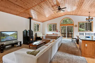 a living room with a couch and a tv at Truckee Pines Retreat - Game Room & Forest Views in Truckee