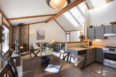 an open kitchen and living room with a table and chairs at Valley View Bliss - Nearby Bike Trails & Beach in Olympic Valley