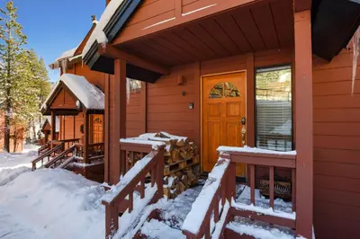 a cabin in the snow with a front door at Valley View Bliss - Nearby Bike Trails & Beach in Olympic Valley