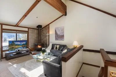 a living room with a couch and a tv at Valley View Bliss - Nearby Bike Trails & Beach in Olympic Valley