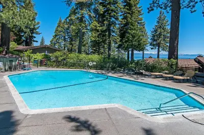 a large swimming pool in a yard with trees at Waters Edge Jewel with Lake Views - HOA Access in Tahoma