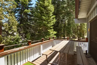 a wooden deck with a bench on a house at Waters Edge Oasis - Shared Pool & Pier Access in Tahoma