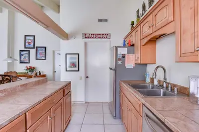 a kitchen with a sink and a refrigerator at Waters Edge Vista - HOA Pool & Pier Access in Tahoma