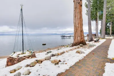 a walkway next to the water with a tree at Waters Edge Vista - HOA Pool & Pier Access in Tahoma