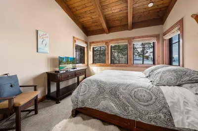 a bedroom with a bed and a desk and windows at West Lake Serenity with 180-Degree Lake Views in Homewood