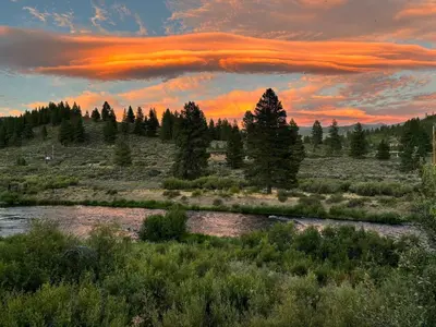 a sunset over a river in a field with trees at West Shore Haven - Near Beach & Outdoor Fun in Tahoma