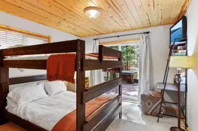 a bedroom with a bunk bed and a sliding glass door at Alpine Gem Near Homewood Mountain in Tahoma