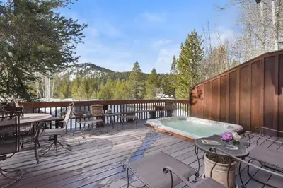 a deck with a pool and a table and chairs at Wulf's Lodge at Olympic Valley - Unwind in Hot Tub in Olympic Valley