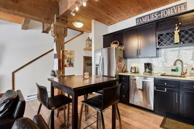 a kitchen with black cabinets and a table and chairs at Alpine Manor Retreat Mountain Relaxation in Alpine Meadows