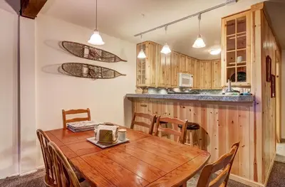 a kitchen and dining room with a wooden table and chairs at Alpine Meadows Peak 15 Min to Commons Beach in Alpine Meadows