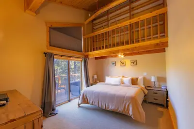 a bedroom with a large bed and a large window at Bearfoot Lodge Near Fishing and Hiking in Truckee