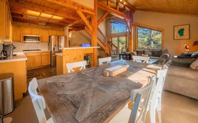 a kitchen and dining room with a large wooden table at Bearfoot Lodge Near Fishing and Hiking in Truckee
