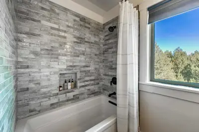 a bathroom with a bath tub and a window at Bearfoot Lodge Near Fishing and Hiking in Truckee