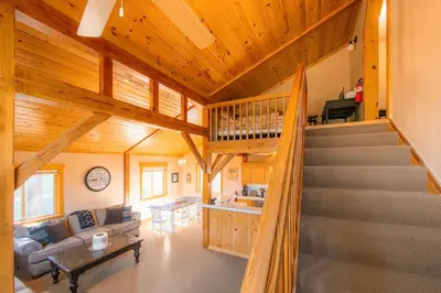 a living room with a staircase in a house at Bearfoot Lodge Near Fishing and Hiking in Truckee