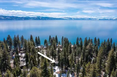 an aerial view of a lake with trees and snow capped mountains at Bright & Modern Cabin Luxury Home in Carnelian Bay in Carnelian Bay