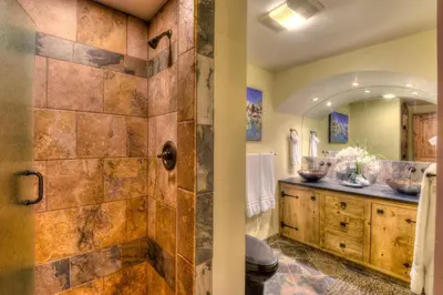 a bathroom with a shower with a stone wall at Brockway Springs Lodge Steps to Lake Access in Kings Beach